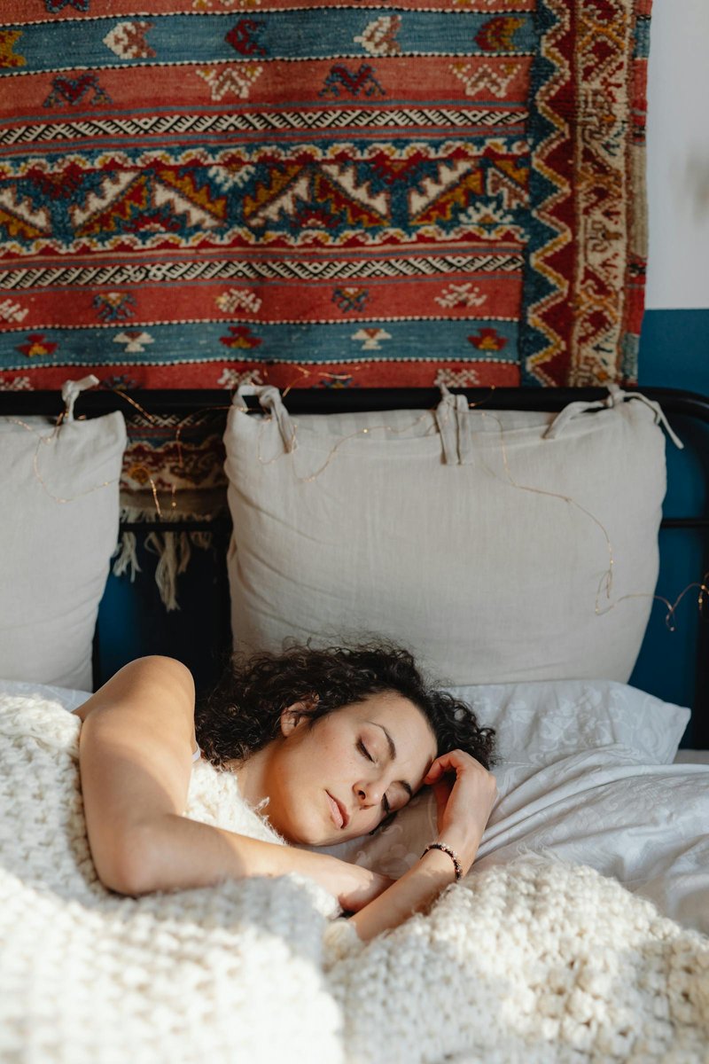 Mulher dormindo em uma cama aconchegante - representando a necessidade de descanso real para quem vive com doença crônica